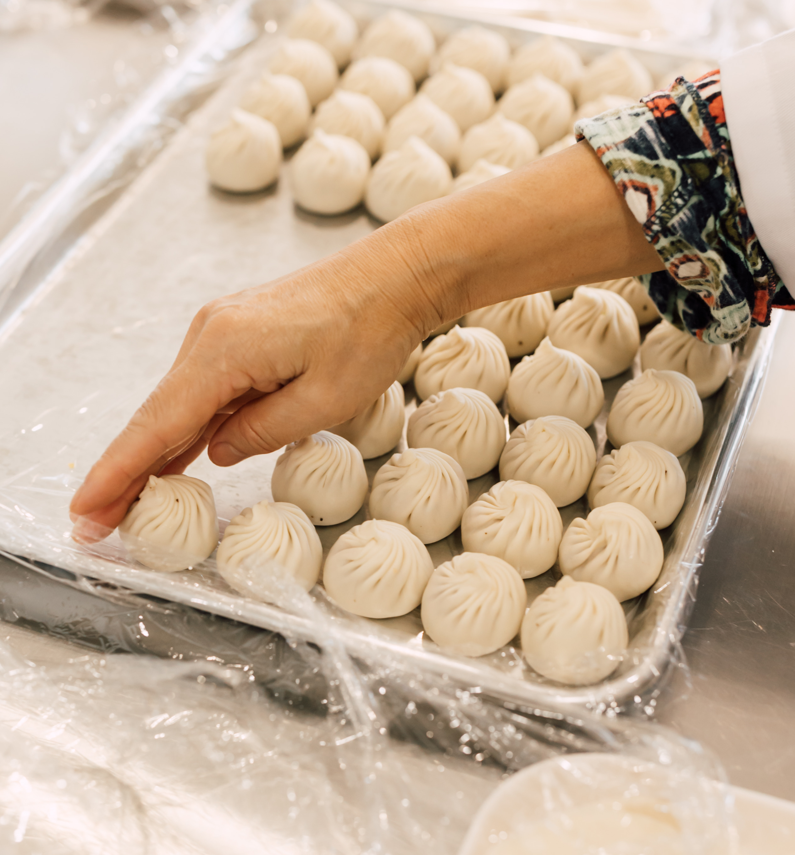 Hand selecting freshly made xiao long bao