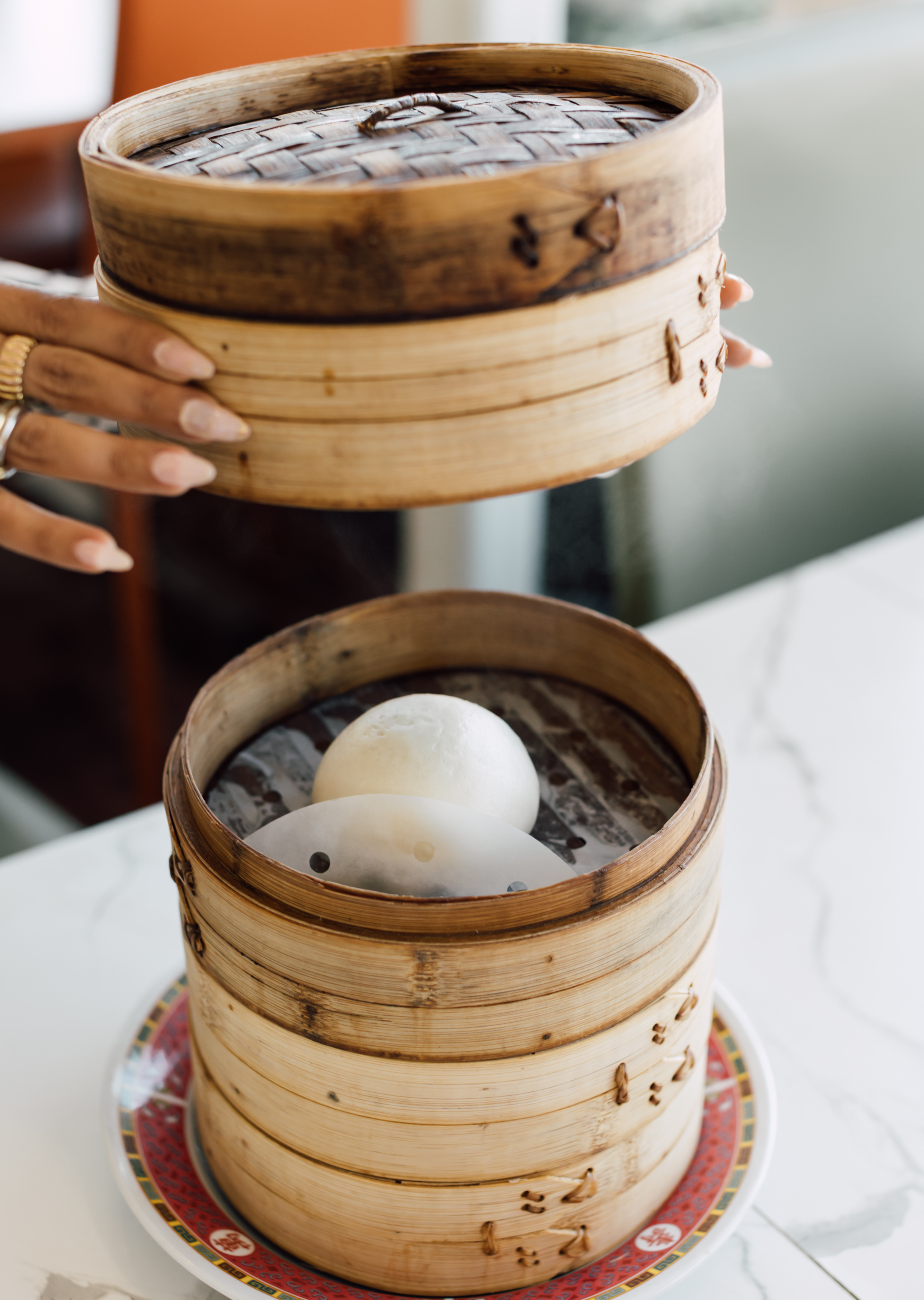 Bamboo steamer opened to reveal a steamed bao